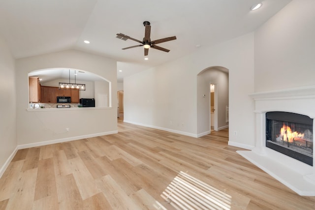 479 Sausalito Dr, Rockwall, TX 75087 - unfurnished living room featuring vaulted ceiling, a ceiling fan, recessed lighting, a lit fireplace, and light wood-style flooring