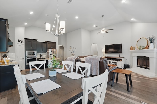 520 Shoreline Ridge Dr, Little Elm, TX 75068 - dining area featuring high vaulted ceiling, arched walkways, ceiling fan, a fireplace, and wood finished floors