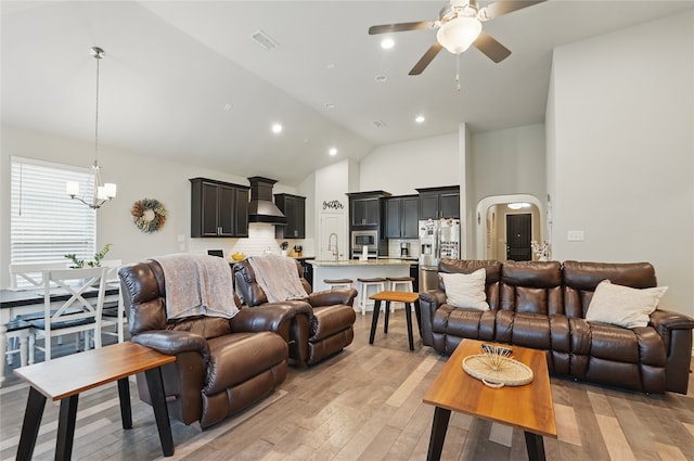 520 Shoreline Ridge Dr, Little Elm, TX 75068 - living area with light wood-style floors, ceiling fan, a chandelier, high vaulted ceiling, and arched walkways