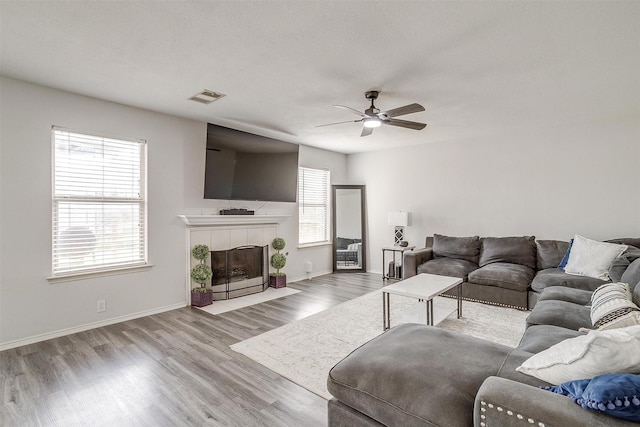 1308 Stetson Trl, Saginaw, TX 76131 - living room featuring wood finished floors, a ceiling fan, a fireplace, and baseboards