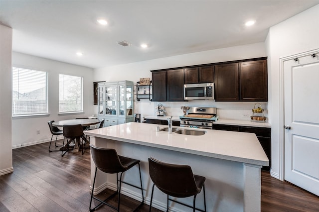 791 Evergreen St, Princeton, TX 75407 - kitchen featuring appliances with stainless steel finishes, a sink, a breakfast bar area, light countertops, and dark brown cabinets