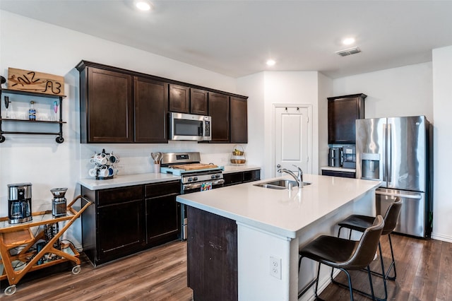 791 Evergreen St, Princeton, TX 75407 - kitchen with stainless steel appliances, a sink, dark wood finished floors, a kitchen bar, and dark brown cabinets