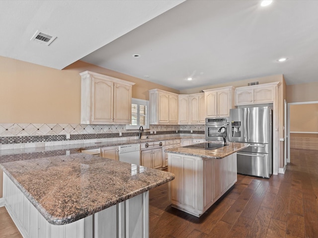333 Forest Trl, Weatherford, TX 76085 - kitchen featuring stainless steel appliances, a peninsula, dark wood-type flooring, light stone countertops, and tasteful backsplash