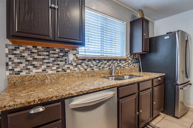 7419 Concordia Ln, Dallas, TX 75241 - kitchen with stainless steel appliances, a sink, backsplash, light stone countertops, and a textured ceiling