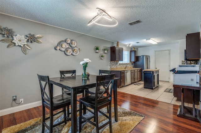 7419 Concordia Ln, Dallas, TX 75241 - dining area with light wood-style flooring and a textured ceiling