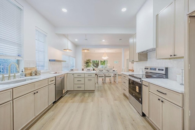 1410 Lee Ave, Fort Worth, TX 76164 - kitchen with stainless steel appliances, a sink, a peninsula, light wood-style floors, and tasteful backsplash