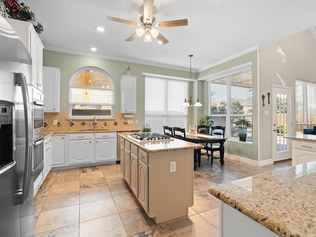 2448 Sky Harbor Dr, Plano, TX 75025 - kitchen with a sink, stainless steel appliances, ornamental molding, a ceiling fan, and decorative backsplash