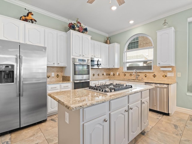 2448 Sky Harbor Dr, Plano, TX 75025 - kitchen with stainless steel appliances, a sink, a center island, white cabinets, and crown molding