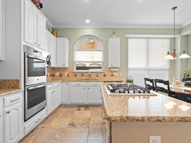 2448 Sky Harbor Dr, Plano, TX 75025 - kitchen featuring stainless steel appliances, a center island, a sink, ornamental molding, and white cabinets