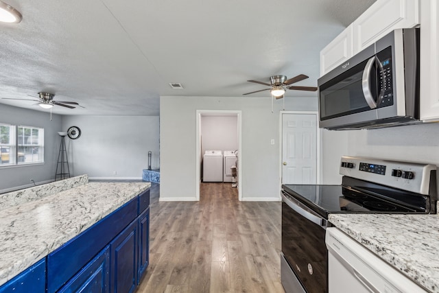 5225 Ira St N, Haltom City, TX 76117 - kitchen with appliances with stainless steel finishes, blue cabinetry, a ceiling fan, and washing machine and dryer