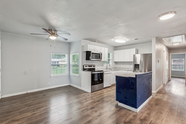 5225 Ira St N, Haltom City, TX 76117 - kitchen featuring stainless steel appliances, a sink, ceiling fan, baseboards, and white cabinetry