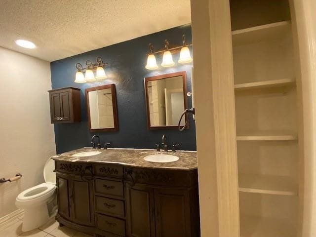 3801 14th St Unit 2205, Plano, TX 75074 - full bath featuring a textured ceiling, toilet, double vanity, and tile patterned flooring