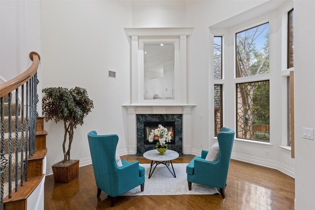 3206 Wintergreen Ter, Grapevine, TX 76051 - sitting room featuring wood finished floors, a fireplace, plenty of natural light, crown molding, and a towering ceiling