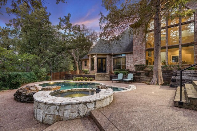 3206 Wintergreen Ter, Grapevine, TX 76051 - pool at dusk featuring a patio and a pool with connected hot tub
