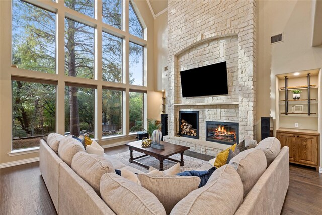 3206 Wintergreen Ter, Grapevine, TX 76051 - living room with a high ceiling, a stone fireplace, dark wood-style floors, and baseboards