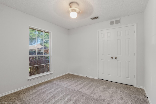 2810 Live Oak Dr, Rowlett, TX 75088 - unfurnished bedroom with carpet, a textured ceiling, a closet, baseboards, and a ceiling fan