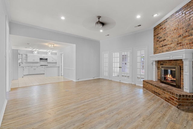 2810 Live Oak Dr, Rowlett, TX 75088 - unfurnished living room featuring ceiling fan, crown molding, light wood-style flooring, a brick fireplace, and recessed lighting
