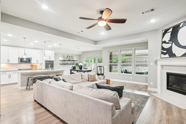 3613 Texas Dall Ct, Mckinney, TX 75071 - living area featuring wood finished floors, ceiling fan, recessed lighting, and a tiled fireplace