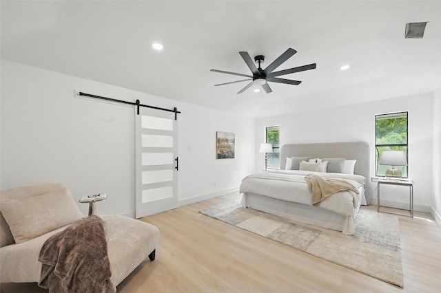 1425 Cassandra Cir, Desoto, TX 75115 - bedroom with a barn door, light wood-style flooring, multiple windows, and recessed lighting