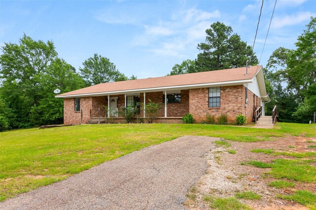 2630 E Lake Dr, Gladewater, TX 75647 - ranch-style home with covered porch, brick siding, and a front yard