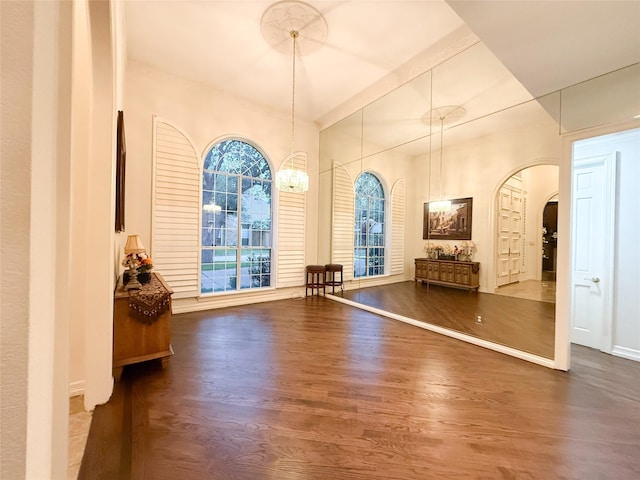 7100 Deer Run, Plano, TX 75024 - foyer entrance with arched walkways, dark wood-style floors, a chandelier, baseboards, and crown molding