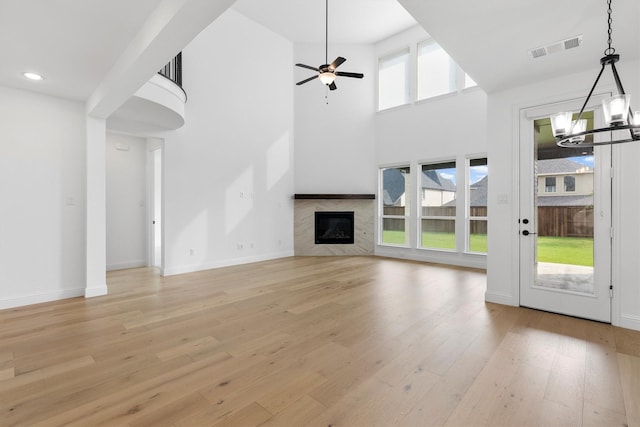 1041 Adair Rd, Prosper, TX 75078 - unfurnished living room featuring light wood-style flooring, a chandelier, a ceiling fan, a premium fireplace, and recessed lighting