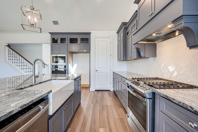 4005 Hollandwood Dr, Mckinney, TX 75071 - kitchen featuring appliances with stainless steel finishes, a sink, light stone countertops, and gray cabinetry