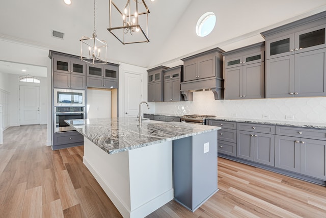 4005 Hollandwood Dr, Mckinney, TX 75071 - kitchen with stainless steel appliances, gray cabinets, a sink, decorative backsplash, and high vaulted ceiling