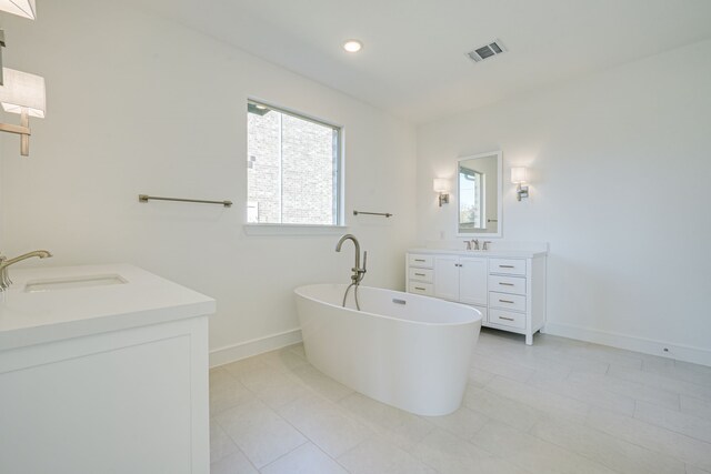 4005 Hollandwood Dr, Mckinney, TX 75071 - full bath with two vanities, baseboards, a soaking tub, and recessed lighting