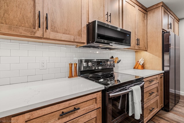 2012 Island Cir, Tool, TX 75143 - kitchen featuring electric range oven, freestanding refrigerator, light countertops, wood finished floors, and decorative backsplash