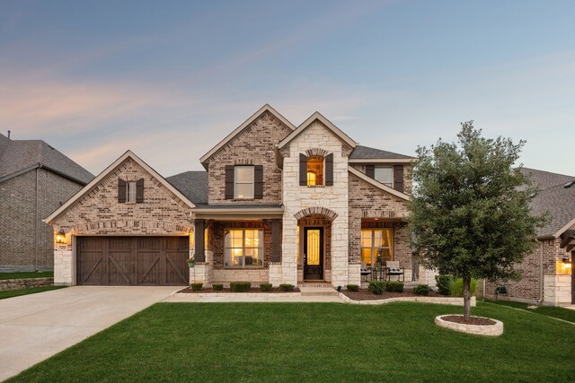 14326 Sedgegrass Dr, Frisco, TX 75033 - french country inspired facade with a lawn, driveway, brick siding, stone siding, and a garage
