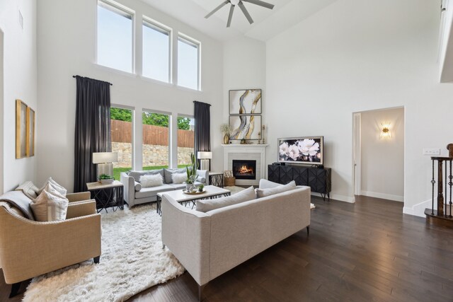 14326 Sedgegrass Dr, Frisco, TX 75033 - living area featuring a high ceiling, ceiling fan, dark wood-style floors, a lit fireplace, and baseboards