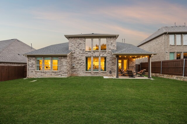 14326 Sedgegrass Dr, Frisco, TX 75033 - back of house at dusk featuring brick siding, a patio, and roof with shingles