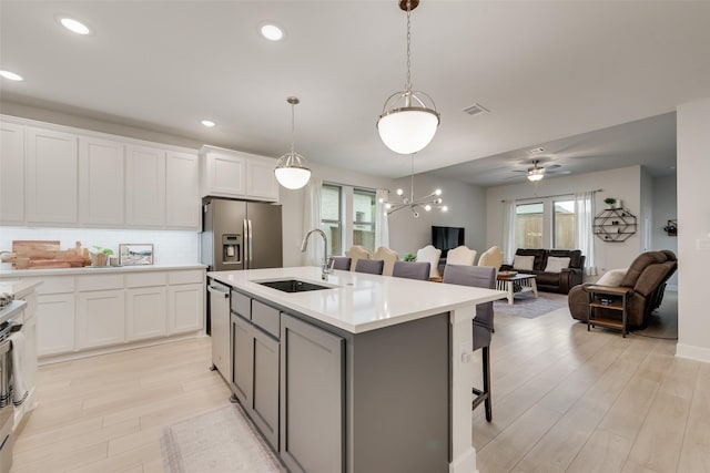3044 Wind Knot Way, Royse City, TX 75189 - kitchen with stainless steel appliances, a sink, light wood finished floors, white cabinets, and backsplash