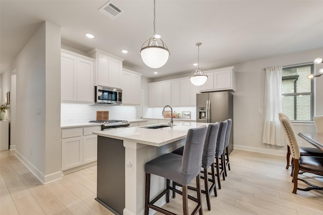 3044 Wind Knot Way, Royse City, TX 75189 - kitchen featuring appliances with stainless steel finishes, a sink, baseboards, light wood-style flooring, and decorative backsplash
