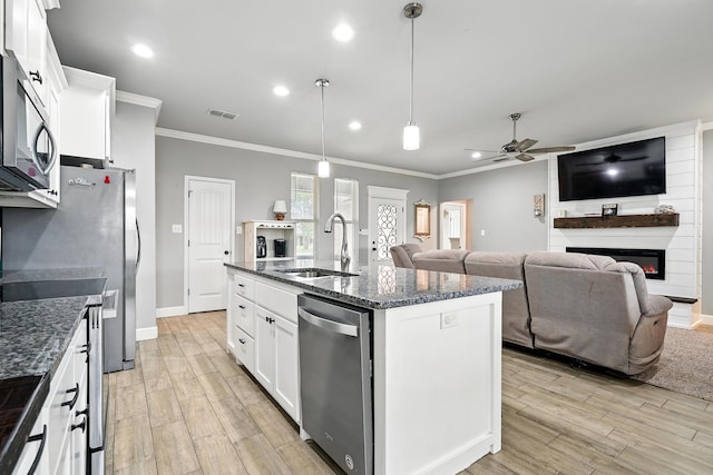 925 8th St, Tuscola, TX 79562 - kitchen with stainless steel dishwasher, a sink, ornamental molding, ceiling fan, and a large fireplace