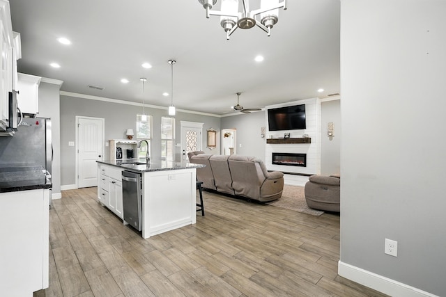 925 8th St, Tuscola, TX 79562 - kitchen with a sink, ornamental molding, a large fireplace, appliances with stainless steel finishes, and an island with sink