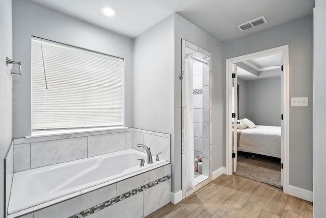 925 8th St, Tuscola, TX 79562 - bathroom with a stall shower, ensuite bathroom, a bath, wood finished floors, and baseboards