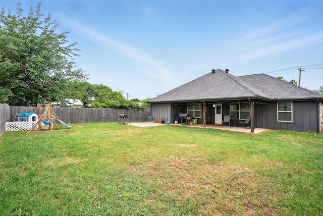 925 8th St, Tuscola, TX 79562 - back of property featuring a patio, board and batten siding, roof with shingles, and a playground