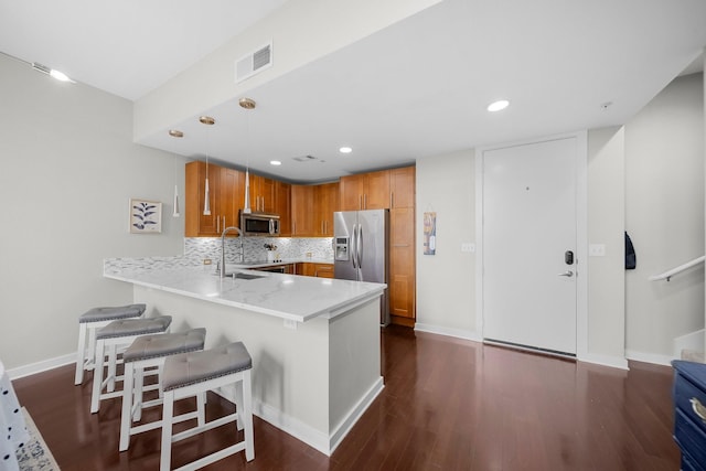 2608 Museum Way Unit 3417, Fort Worth, TX 76107 - kitchen featuring appliances with stainless steel finishes, a peninsula, a sink, dark wood-type flooring, and a kitchen breakfast bar