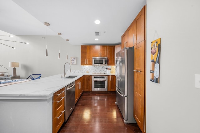 2608 Museum Way Unit 3417, Fort Worth, TX 76107 - kitchen featuring stainless steel appliances, a sink, dark wood finished floors, a peninsula, and brown cabinetry