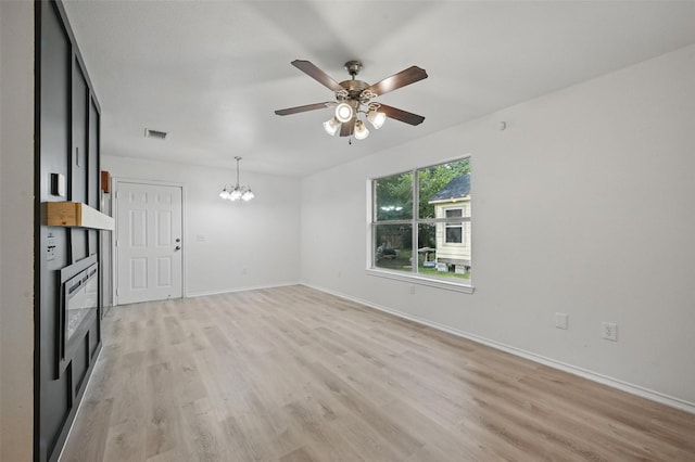714 E 12th St, Bonham, TX 75418 - unfurnished living room with ceiling fan, light wood-type flooring, baseboards, and a chandelier