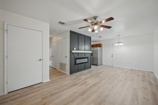 714 E 12th St, Bonham, TX 75418 - unfurnished living room featuring ceiling fan, a chandelier, light wood-type flooring, and baseboards