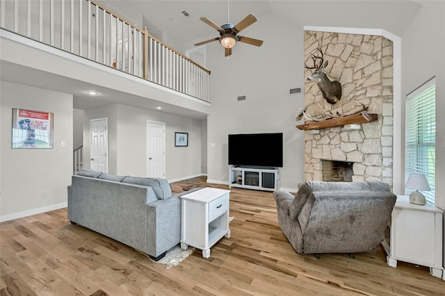 11605 Fm 697, Whitewright, TX 75491 - living area featuring a ceiling fan, high vaulted ceiling, light wood finished floors, a stone fireplace, and baseboards