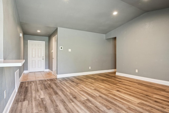 1509 Cedar Keys Dr, Lewisville, TX 75067 - empty room with wood finished floors, vaulted ceiling, baseboards, and recessed lighting