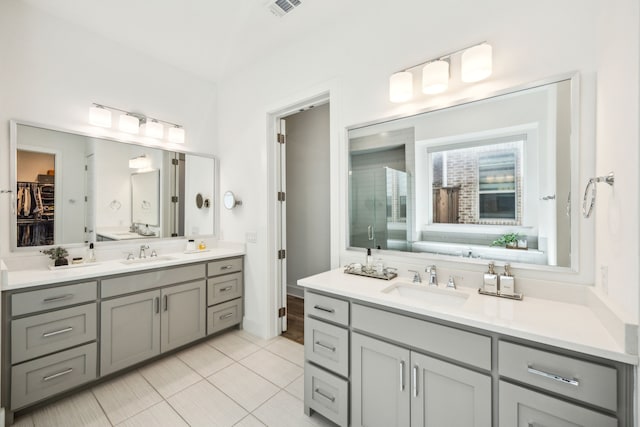 927 Leola Ln, Allen, TX 75013 - full bathroom featuring a stall shower, tile patterned flooring, two vanities, and a walk in closet