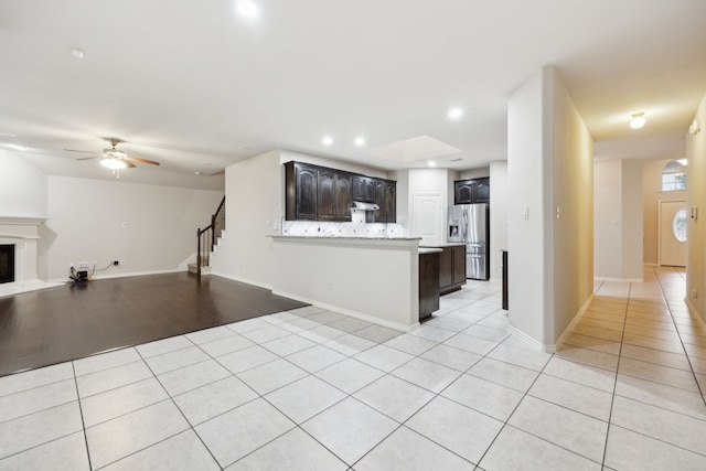 912 Kittery Dr, Desoto, TX 75115 - kitchen with stainless steel fridge, open floor plan, light tile patterned flooring, a peninsula, and light countertops