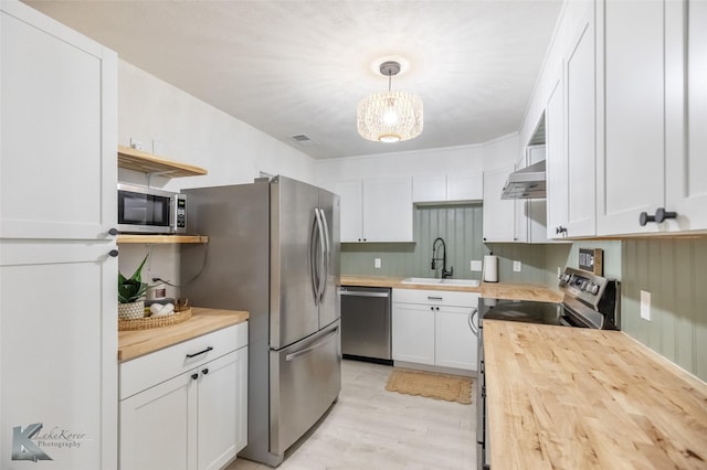 1518 Weavers Way, Abilene, TX 79602 - kitchen featuring wooden counters, stainless steel appliances, a sink, under cabinet range hood, and white cabinetry