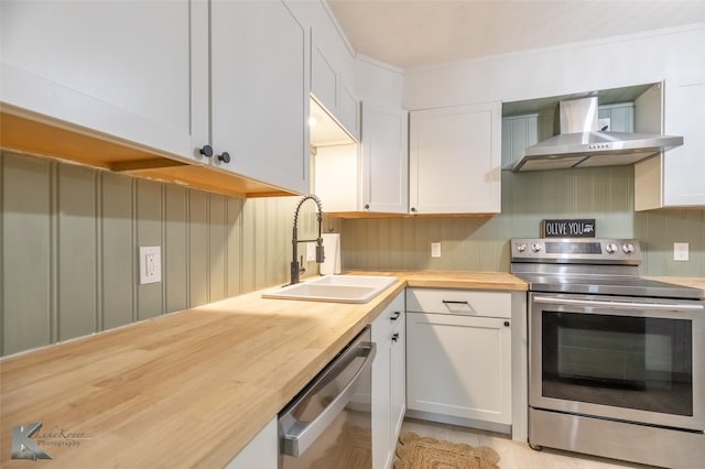 1518 Weavers Way, Abilene, TX 79602 - kitchen featuring appliances with stainless steel finishes, wall chimney exhaust hood, butcher block counters, a sink, and white cabinets