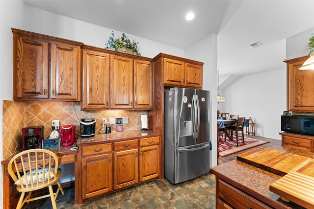 1114 Mount Ln, Rhome, TX 76078 - kitchen with stainless steel fridge with ice dispenser, black microwave, brown cabinets, tasteful backsplash, and recessed lighting